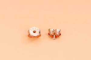 Macro shot of 18K rose gold plated S925 sterling silver butterfly earring backs with hallmark