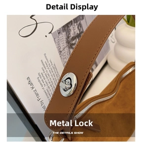 Close-up of a silver metal swivel lock and fine stitching on a vintage suede handbag