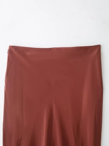 Detail view of the rust red satin skirt waistline featuring a hidden side zipper closure