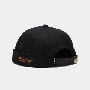Detail of adjustable metal buckle and keep going logo label on black docker hat