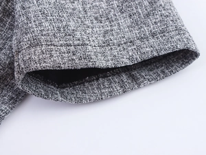 Detailed macro view of gray-white tweed fabric texture and black inner lining stitching