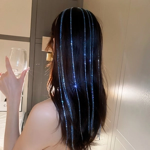 Close-up of blue rhinestone long tassel hair chain flowing down dark hair