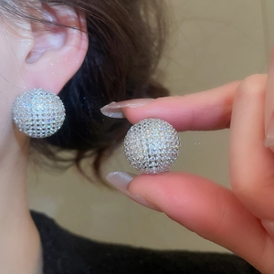 Detailed view of shimmering pave zircon sphere earrings on ear for a minimalist look