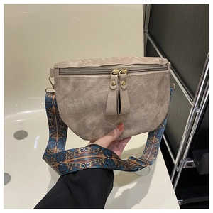 Détail du sac bandoulière demi-lune kaki avec sangle tissée et fermetures éclair dorées