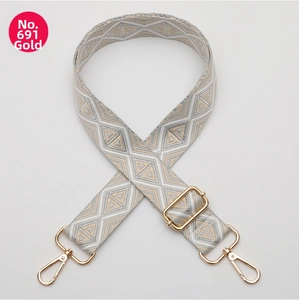 Detailed view of geometric diamond woven bag strap with adjustable gold metal buckle