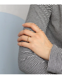 Close-up of a minimalist hollow heart-shaped gold ring worn on a model finger