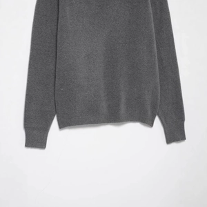 Front view of a grey off-shoulder knit sweater with ribbed cuffs and hem details