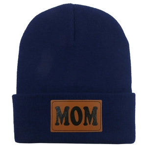 Détail de l'écusson en cuir MOM sur le bonnet en tricot bleu marine pour femme