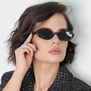 Vintage oval black sunglasses with glossy frames on female model in soft light
