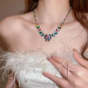 Close-up of sparkling colorful zircon leaf and heart necklace on a model's neck