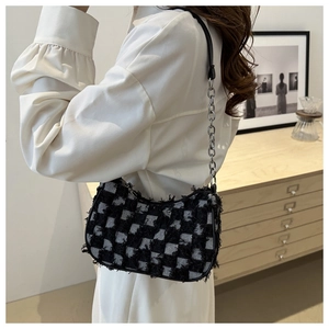 Ethnic style black and white checkered underarm bag with chain strap on a model