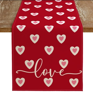 Detail of red Valentine's Day table runner with love heart patterns on wood surface