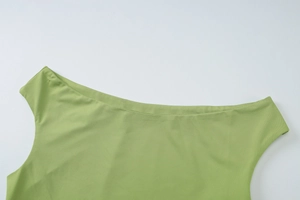 Detail of the grass green sloping neckline and fine knit texture of the slim fit top
