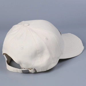 Detail of cotton baseball cap featuring adjustable metal buckle and distressed brim edge