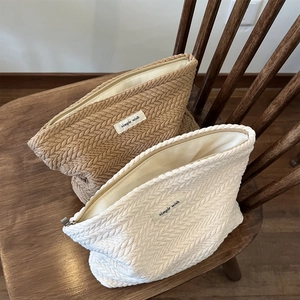 Close-up of crochet texture on knit pouch bags with simple wish labels on a wood chair