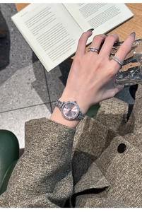Close-up of elegant silver women watch with rose gold dial and matching crystal rings