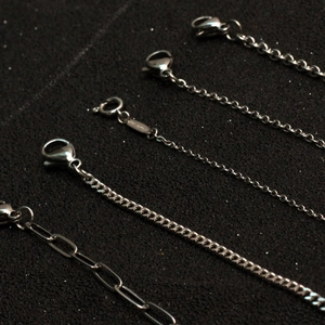 Assorted silver stainless steel chains featuring curb, cable, and paperclip styles