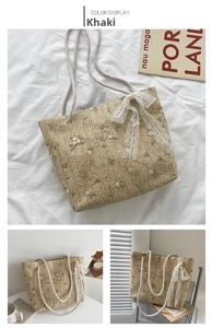 Detail of khaki straw tote bag featuring floral embroidery and white lace bow decoration