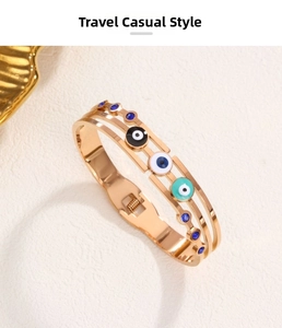 Detail of gold evil eye bangle with enamel rings and blue crystals in a layered design