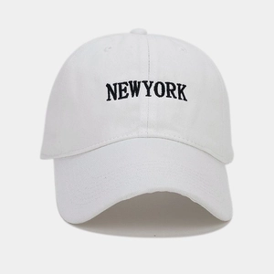 Dettaglio ravvicinato del ricamo NEW YORK su un cappellino da baseball in cotone bianco