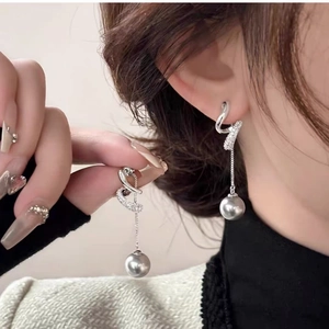 Detail of silver twisted rhinestone earrings with long tassels and grey pearl charms