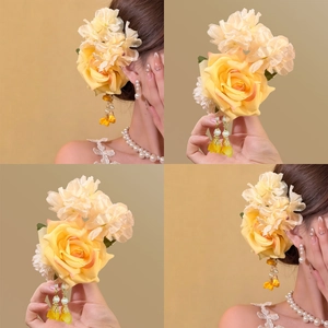 Detail of yellow flower hair clip with pearl tassels on a golden background