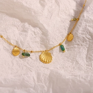 Gros plan du pendentif coquillage plaqué or 18K et perles de pierre verte sur chaîne