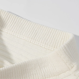 Detailansicht der hochwertigen cremeweißen Strickstruktur mit feinen Nähten am Kragenrand
