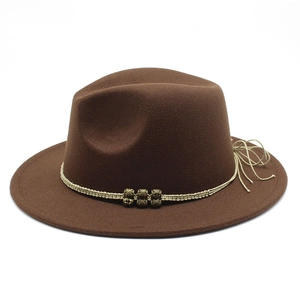 Detailed macro view of brown fedora hat featuring woven beige cord and gold metal beads