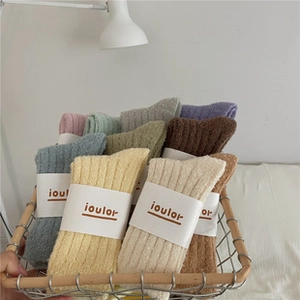 Detail of colorful coral fleece mid-tube socks with vertical stripes in a white basket