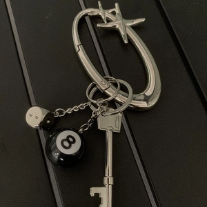 Detail of star oval carabiner with dice, billiard ball 8 and key bottle opener pendant
