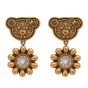 Vintage gold bear and flower earrings with sparkling zircon crystals on white backdrop