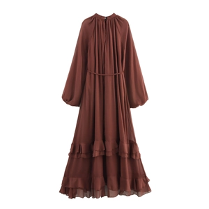 Abito lungo bohémien in chiffon marrone con maniche lunghe e orlo a balze su sfondo bianco