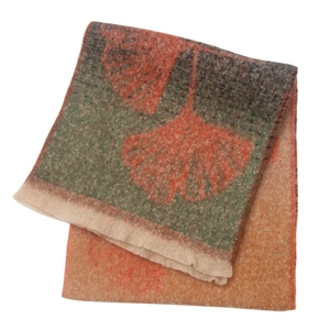 Detailed view of soft ginkgo leaf pattern jacquard scarf with fringe in warm fall colors