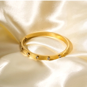 Macro detail of 18k gold plated stainless steel hinge bangle set with sparkling crystals