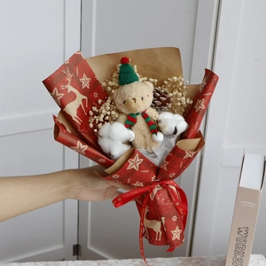 Close-up of a Christmas bear plush bouquet with dried flowers and red reindeer paper