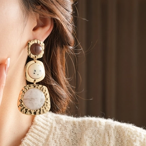 Close-up of vintage multi-layer geometric resin earrings with hammered gold metal frames