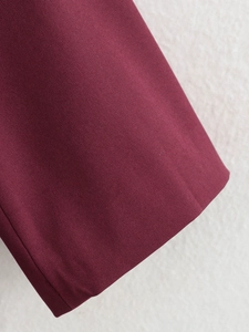 Dettaglio della manica del blazer bordeaux che mostra il tessuto twill e le cuciture