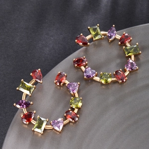 Detailed view of C-shaped open hoop earrings featuring multi-color faceted crystals