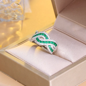 Macro shot of an elegant green gemstone ring with micro-pave diamonds in a gold box