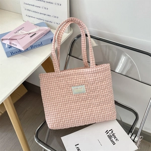 Close-up of pink gingham tote bag with heart quilting on a transparent chair