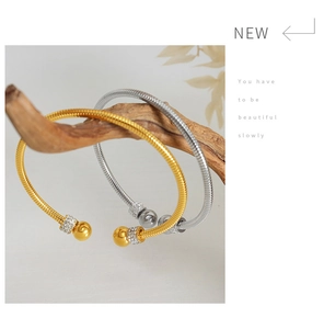 Close-up of gold and silver plated bangles with pavé rhinestones on artistic wood