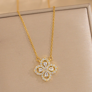 Macro detail of a golden flower pendant necklace with shimmering micro-paved zircons