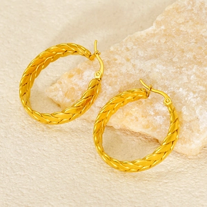Modern 18k gold plated wheat grain hoop earrings on a textured stone surface
