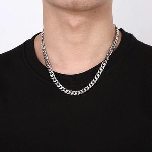 Close-up of a silver titanium steel Cuban link chain necklace worn on a black sweatshirt