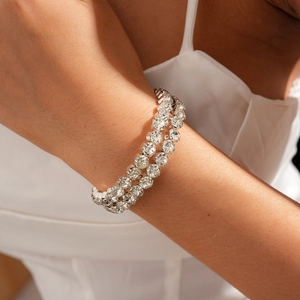 Detailed view of silver double-row rhinestone bracelet on woman wrist with luxury finish