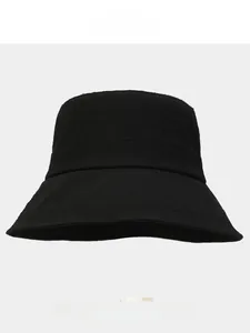 Détail de la texture d'un chapeau bob noir montrant le tissu micro-plissé de qualité