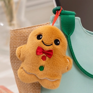 Close-up of a gingerbread man plush pendant with red bow and festive embroidery details