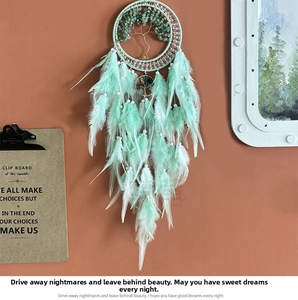 Detailed handmade mint green dreamcatcher featuring a stone tree of life and soft feathers