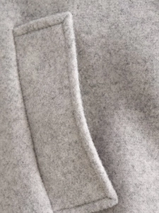 Macro de la texture du tissu en laine grise et détails de couture de la poche latérale